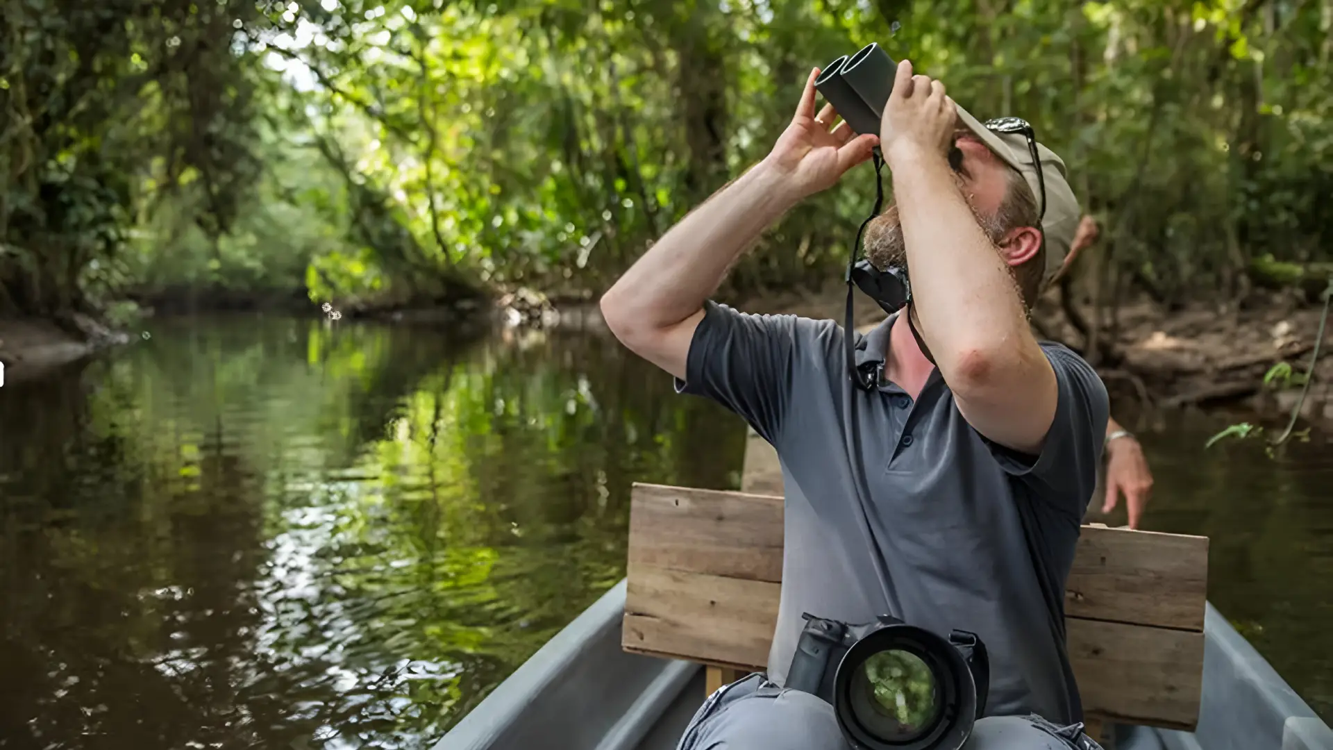 Traveler observing wildlife during a canoe journey in the rainforest