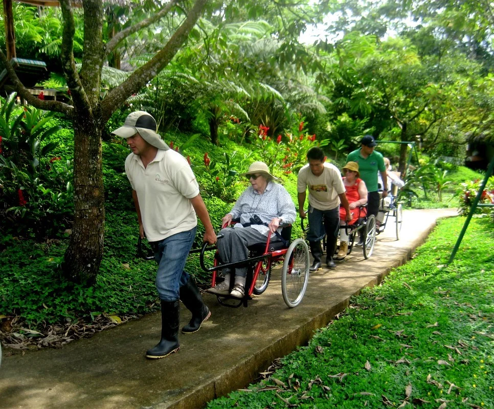 Huésped en silla de ruedas recorriendo las instalaciones accesibles de Huasquila Amazon Lodge