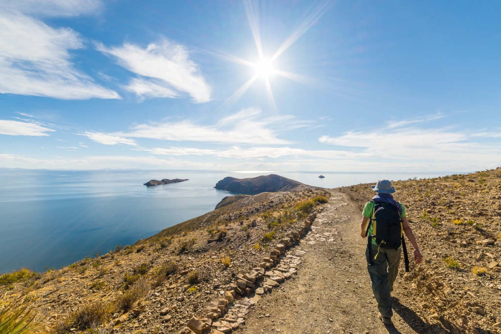Traveller hiking along trails overlooking Lake Titicaca and Isla del Sol in Bolivia